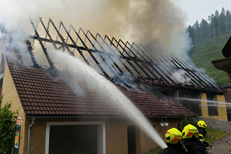 Feuerwehrmänner beim Löschen eines Hausdaches