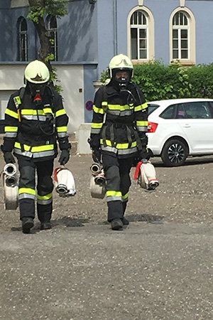 Zwei Feuerwehrmänner tragen die Schläuche