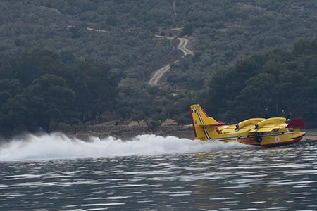 Loeschflugzeug beim Auftanken im See